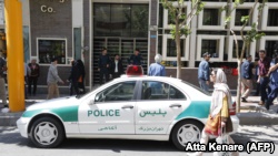 Një veturë e policisë iraniane e parkuar para një dyqani të këmbimit të monedhave në Teheran. 10 prill, 2018